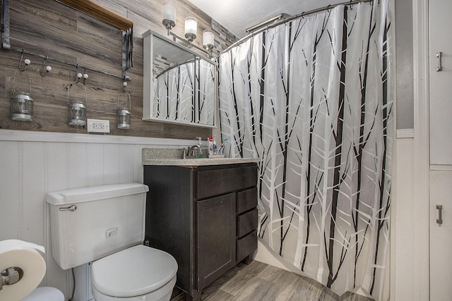 full bathroom featuring hardwood / wood-style flooring, vanity, shower / bath combo, and toilet