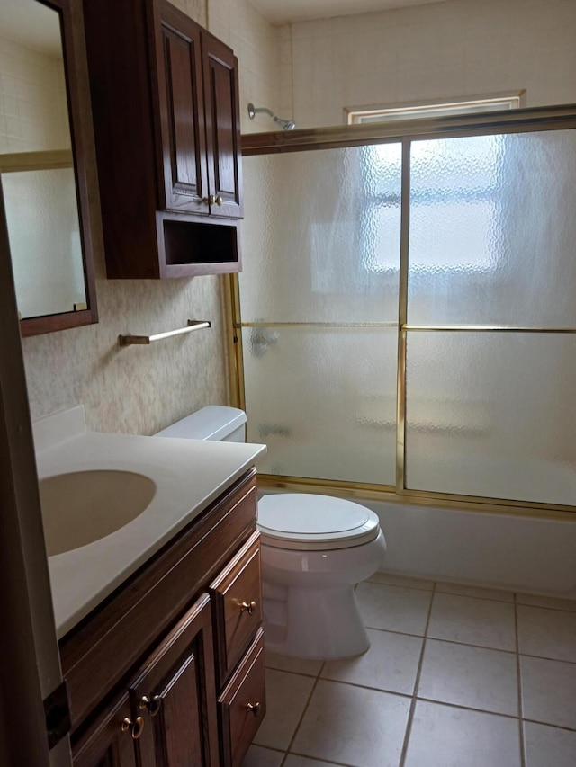 full bath with toilet, tile patterned flooring, bath / shower combo with glass door, and vanity