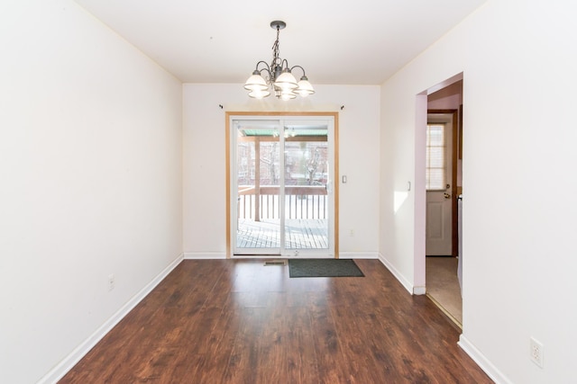 doorway with dark hardwood / wood-style flooring and a notable chandelier