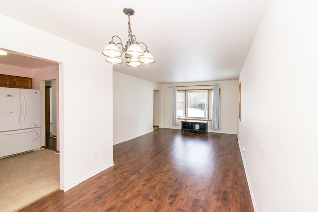 spare room featuring dark hardwood / wood-style floors and a notable chandelier