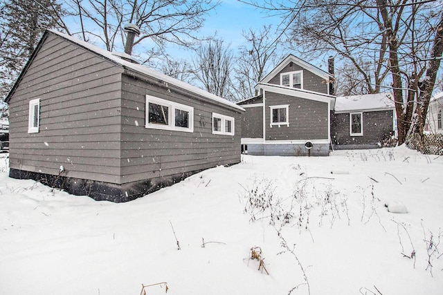 view of snow covered rear of property