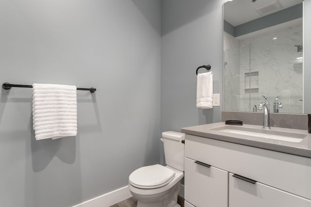 bathroom featuring vanity, toilet, and a shower with shower door