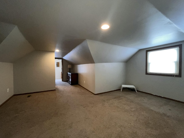 bonus room featuring light colored carpet and lofted ceiling