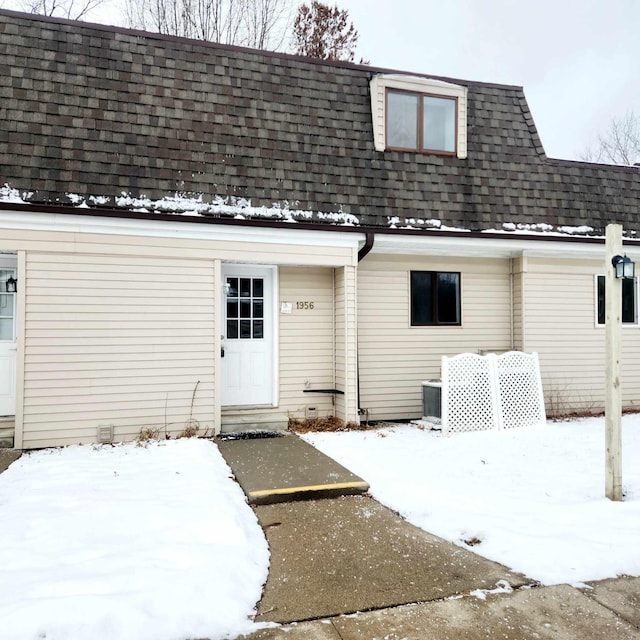 snow covered house with central AC unit