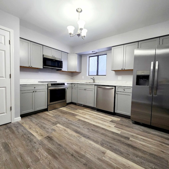 kitchen with pendant lighting, appliances with stainless steel finishes, and gray cabinets