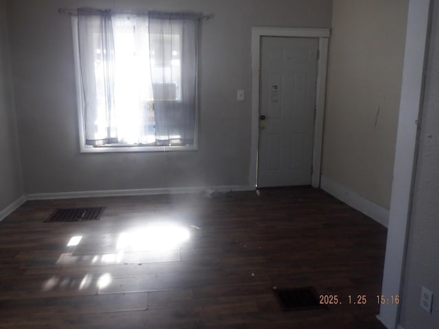 unfurnished room with dark wood-type flooring