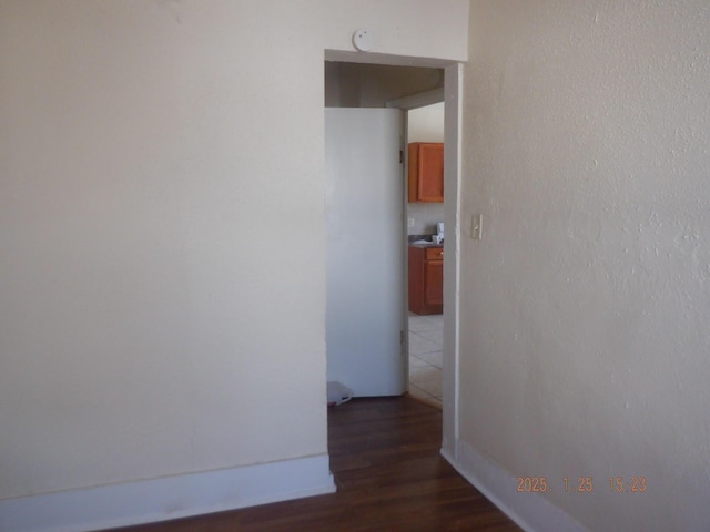 corridor with dark hardwood / wood-style flooring