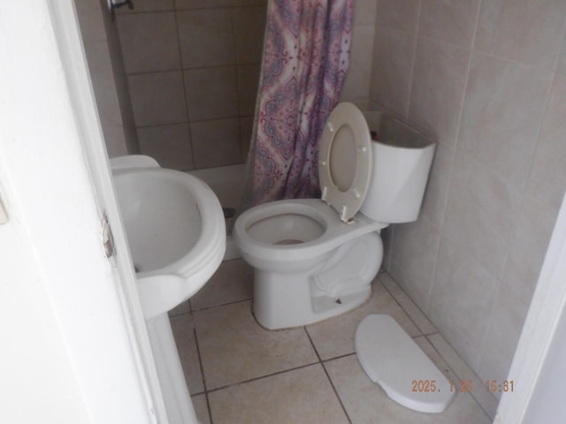 bathroom with tile patterned flooring, tile walls, toilet, and a shower with shower curtain