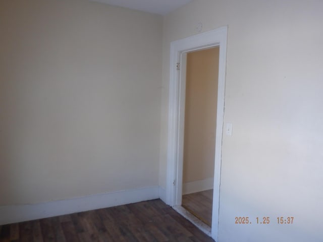 unfurnished room with dark wood-type flooring