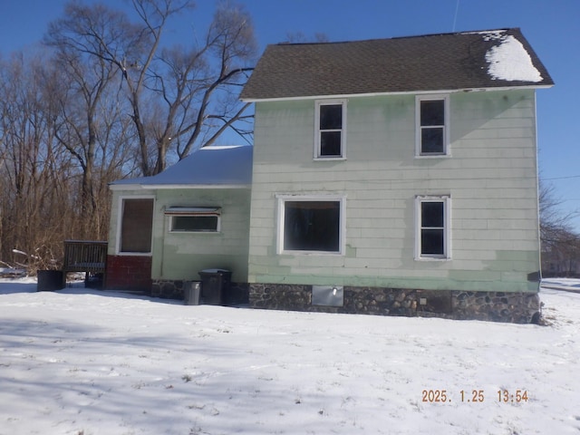 view of snow covered rear of property