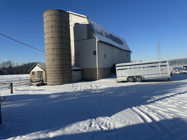 view of snowy exterior featuring an outbuilding