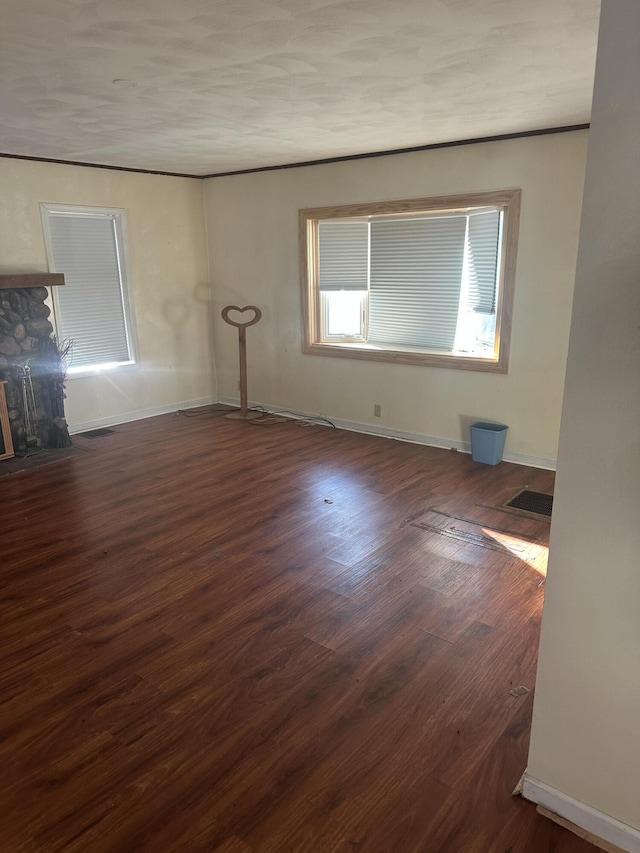 spare room featuring a fireplace and dark hardwood / wood-style floors