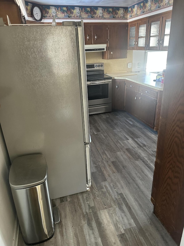 kitchen with dark brown cabinets, dark wood-type flooring, and appliances with stainless steel finishes