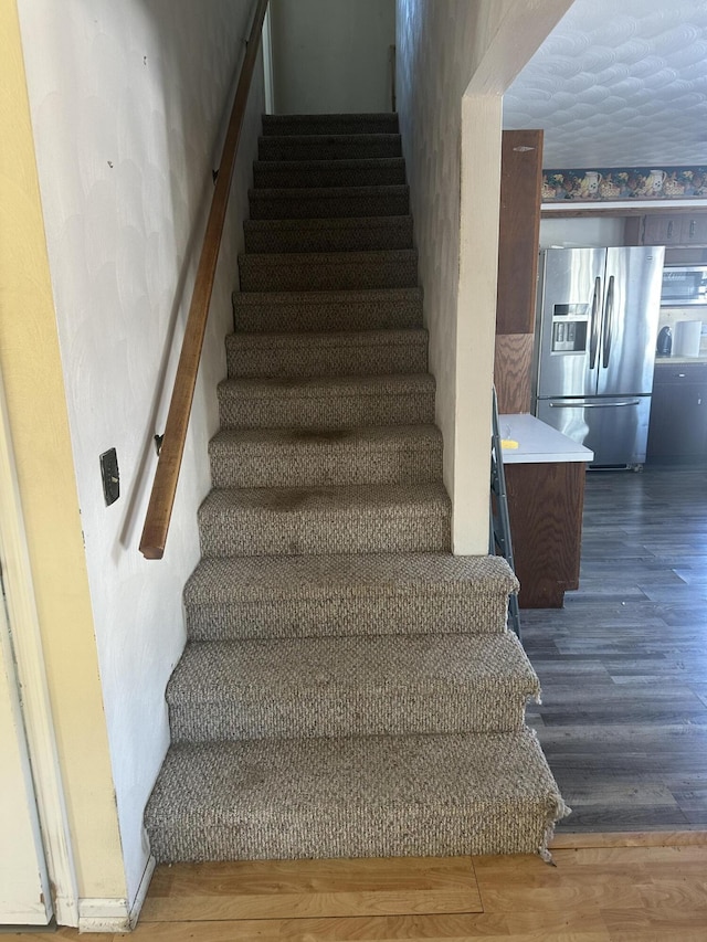 staircase with hardwood / wood-style floors