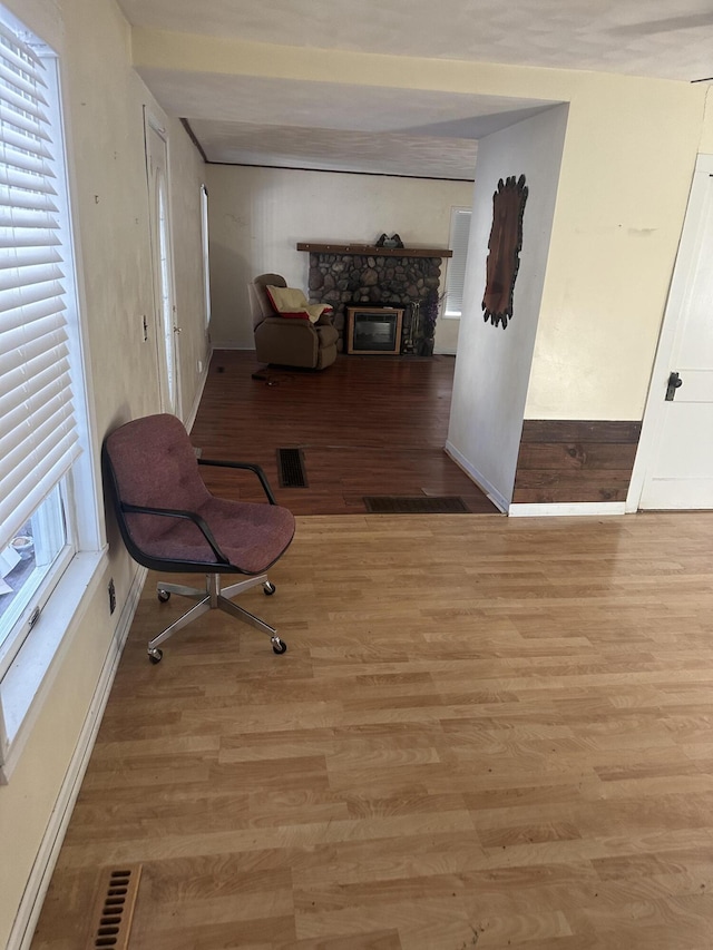 sitting room with a fireplace and light wood-type flooring