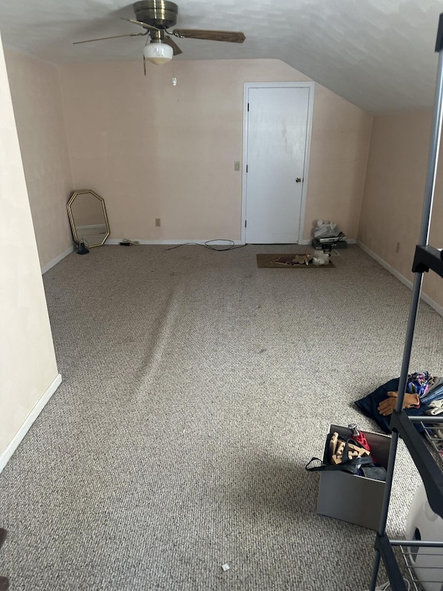 interior space with lofted ceiling, ceiling fan, and carpet