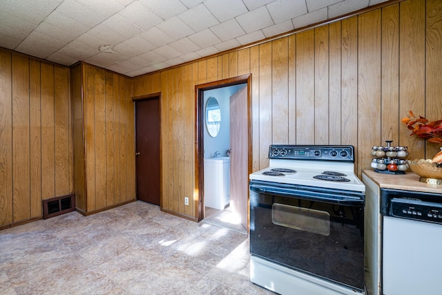 kitchen with range with electric cooktop, dishwasher, and wooden walls