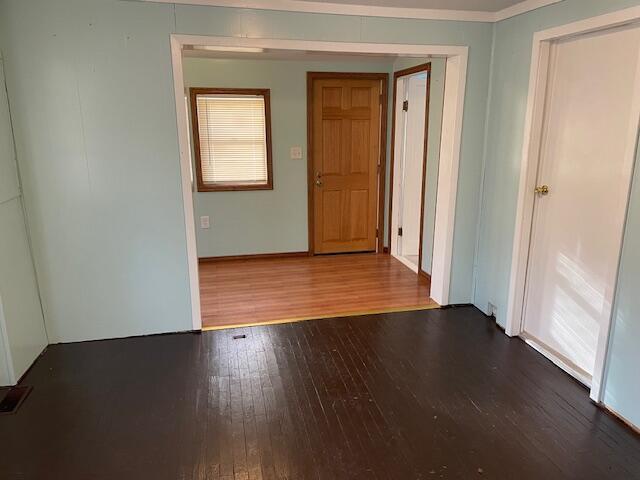 unfurnished room featuring hardwood / wood-style flooring and crown molding