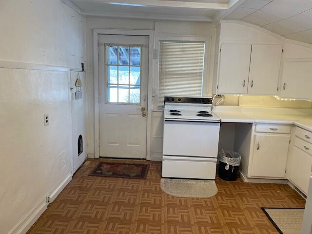 kitchen with white cabinetry, lofted ceiling, parquet floors, and electric range