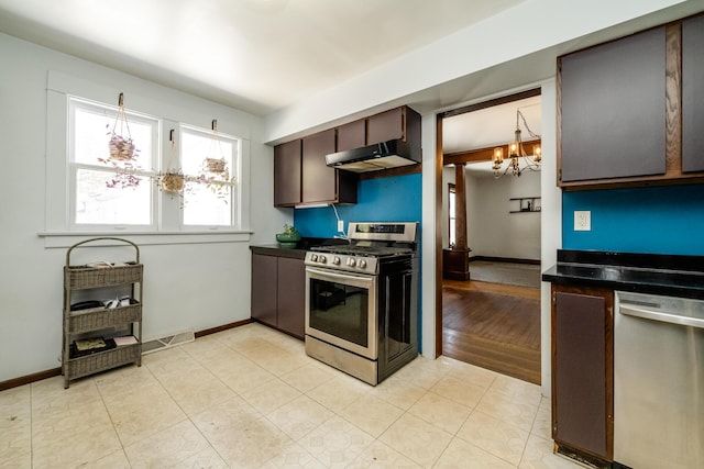 kitchen featuring dark brown cabinetry, appliances with stainless steel finishes, and a chandelier