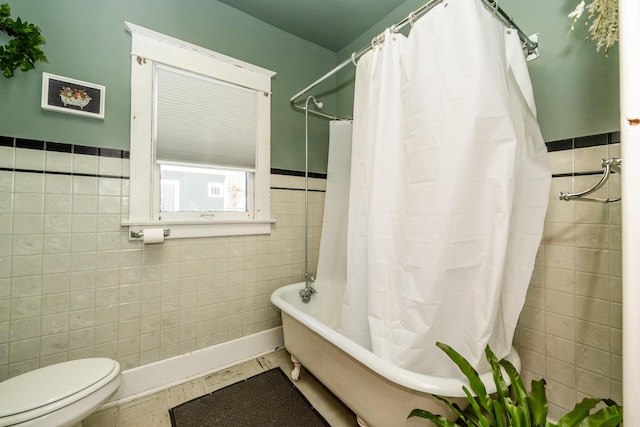 bathroom with tile patterned flooring, tile walls, and toilet