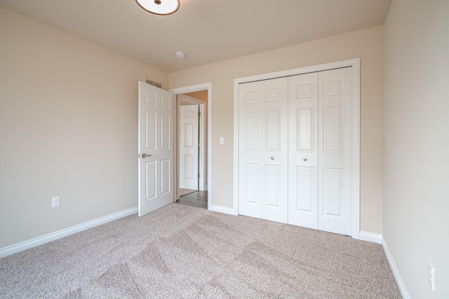 unfurnished bedroom with carpet floors and a closet