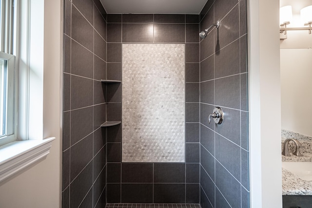 bathroom with vanity and a tile shower