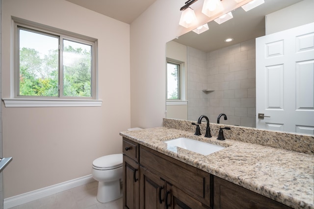 bathroom with vanity, tile patterned floors, toilet, and a healthy amount of sunlight