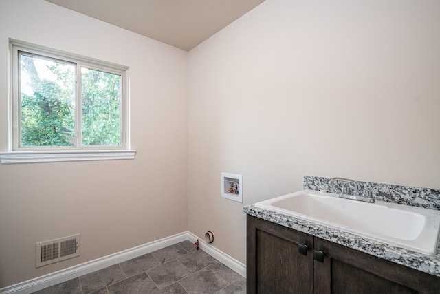 laundry room with hookup for a washing machine, sink, and cabinets