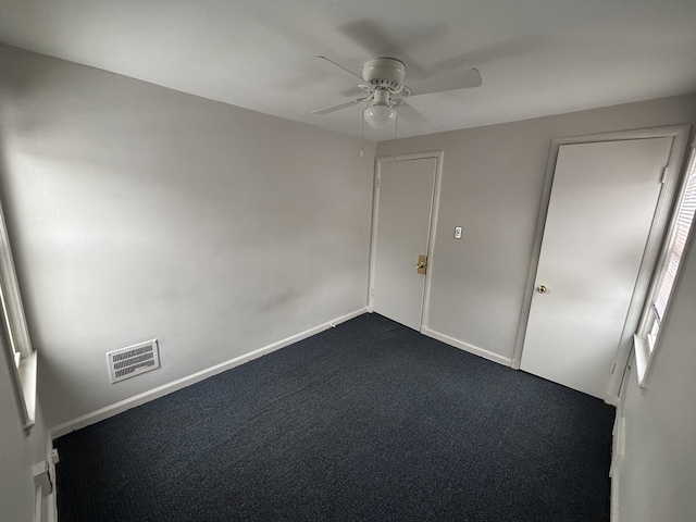 carpeted spare room with ceiling fan