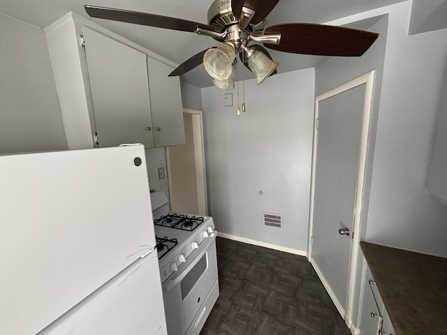 kitchen featuring dark parquet flooring, ceiling fan, white cabinets, and white appliances