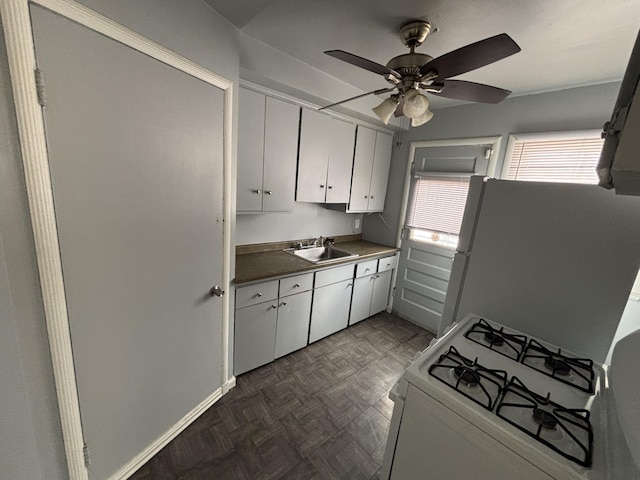 kitchen featuring white cabinetry, white appliances, dark parquet flooring, and sink