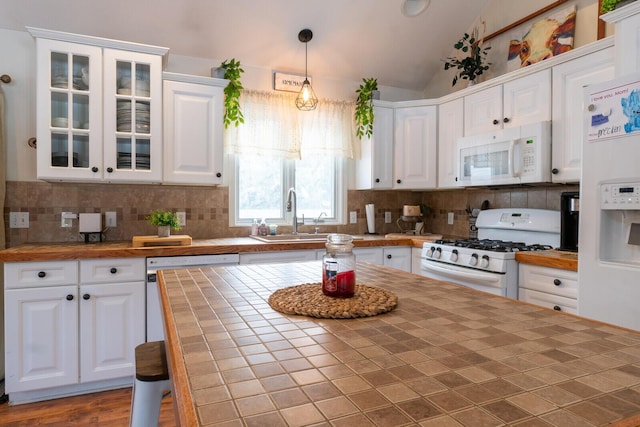 kitchen featuring white cabinetry, white appliances, and tile countertops