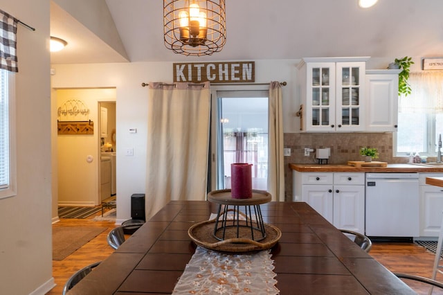 dining room featuring hardwood / wood-style floors, washer / dryer, and vaulted ceiling