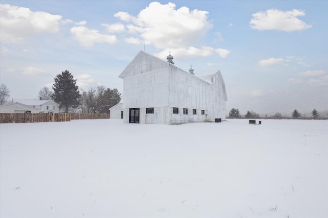 snow covered property with an outbuilding