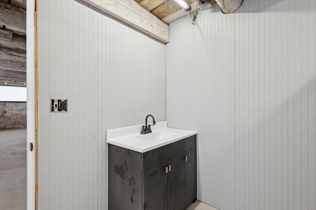 bathroom with vanity and wooden walls