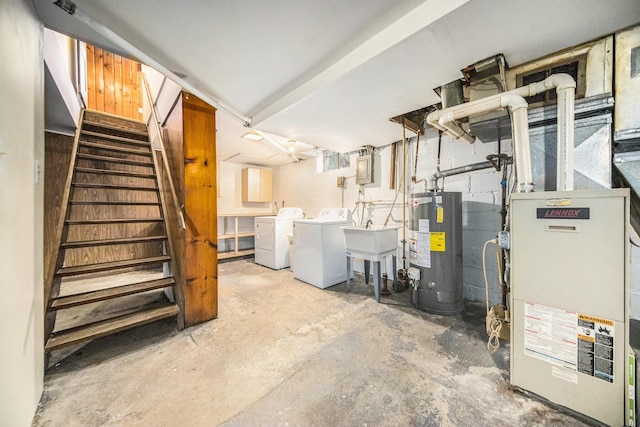 basement featuring heating unit, water heater, and washer and dryer