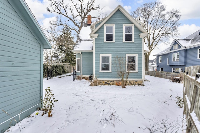 view of snow covered rear of property