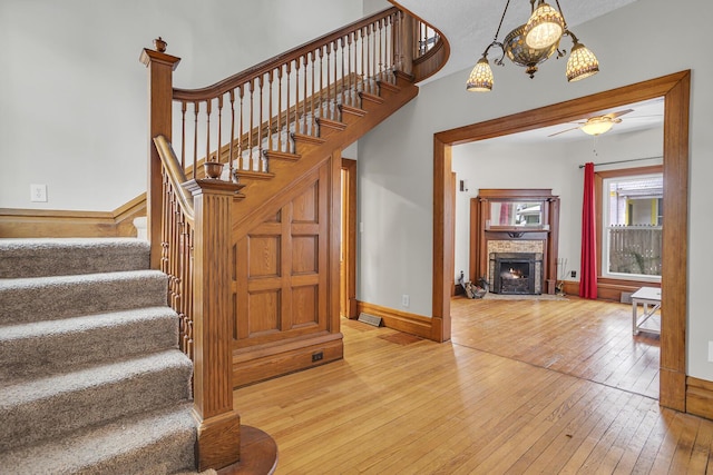 stairs featuring a fireplace and wood-type flooring