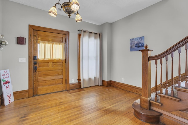 entryway featuring an inviting chandelier and light hardwood / wood-style flooring