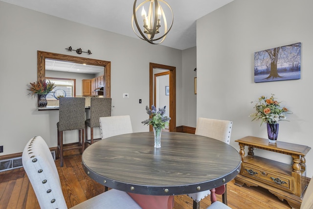 dining area featuring hardwood / wood-style flooring and a chandelier