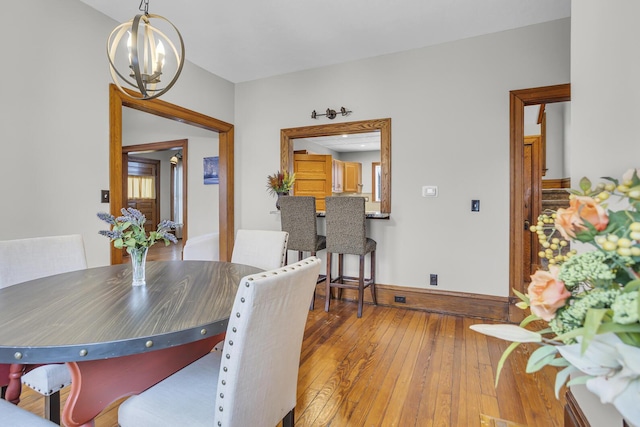 dining area with an inviting chandelier and light wood-type flooring