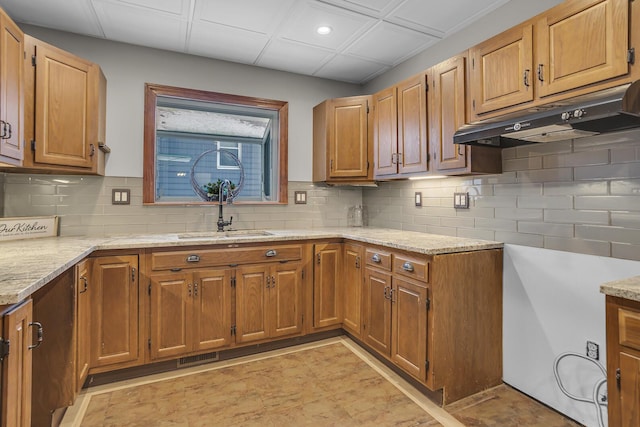 kitchen with light stone countertops, sink, and decorative backsplash