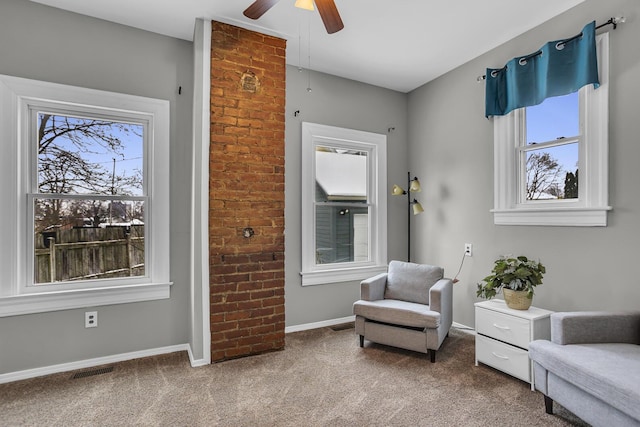 living area featuring carpet and ceiling fan