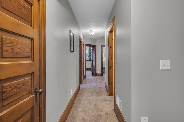 corridor featuring light colored carpet