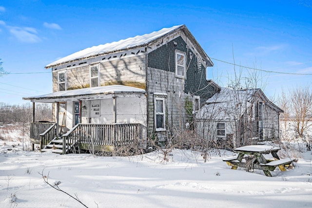 view of snowy exterior with covered porch