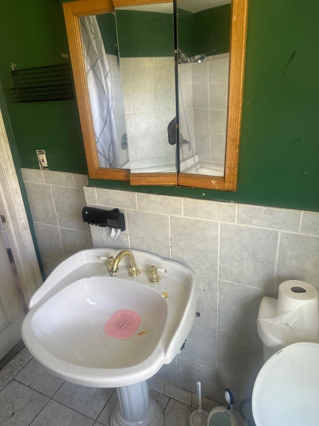 bathroom featuring sink, tile patterned floors, and toilet