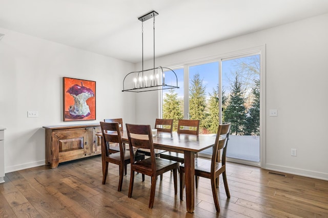 dining space featuring an inviting chandelier and dark hardwood / wood-style flooring