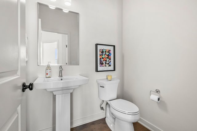 bathroom with hardwood / wood-style flooring and toilet