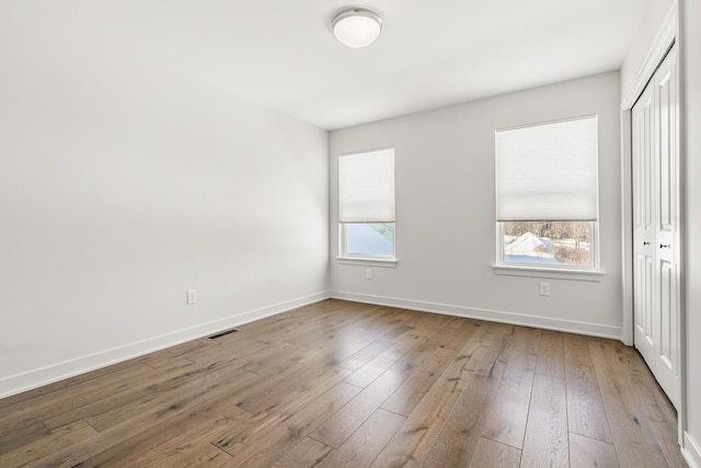 unfurnished bedroom with hardwood / wood-style floors and a closet